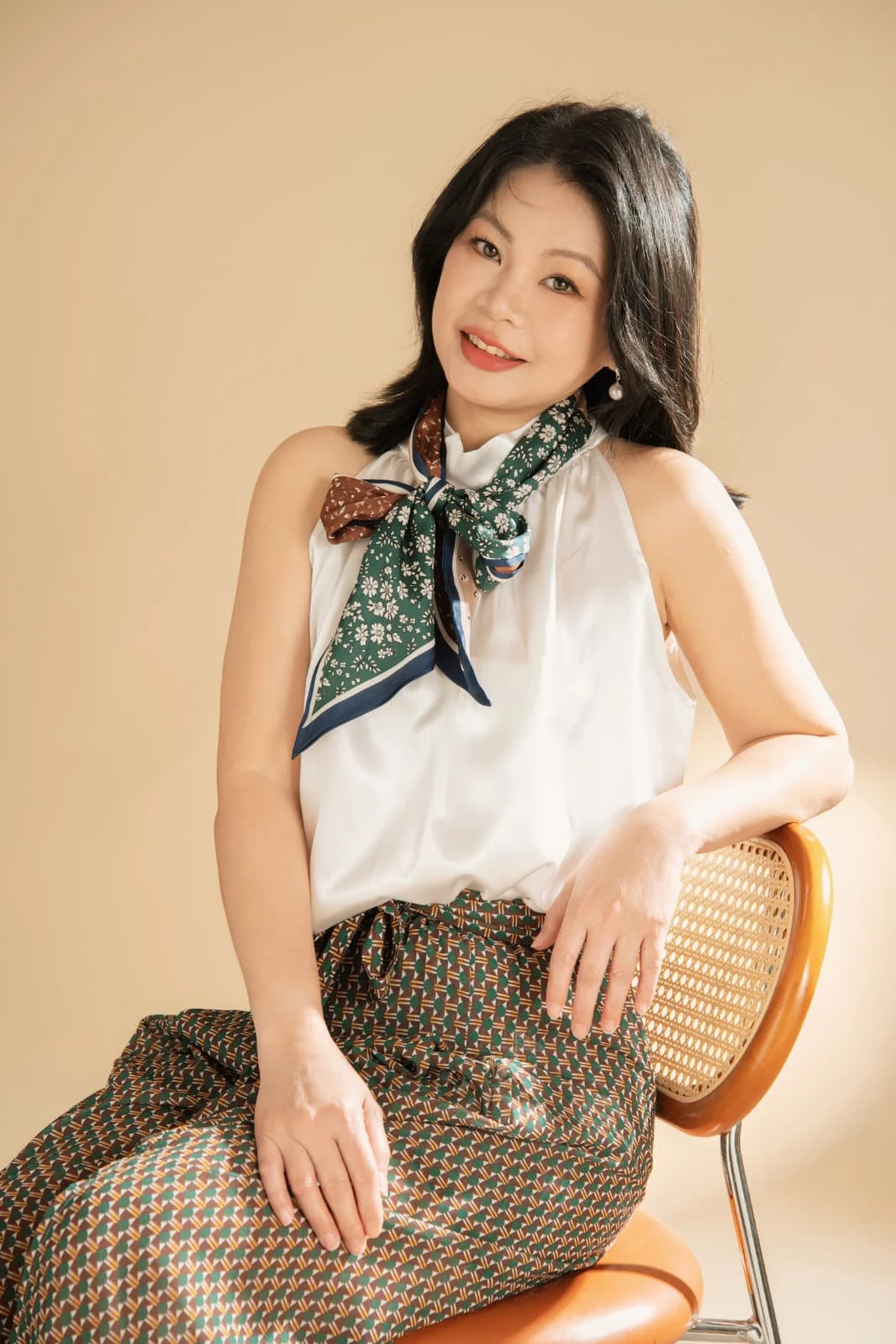 Jewel Beauti founder seated with a patterned scarf